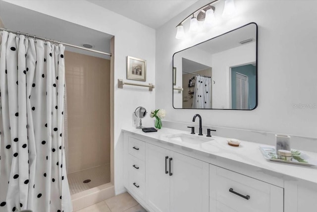 bathroom with curtained shower, vanity, and tile patterned flooring