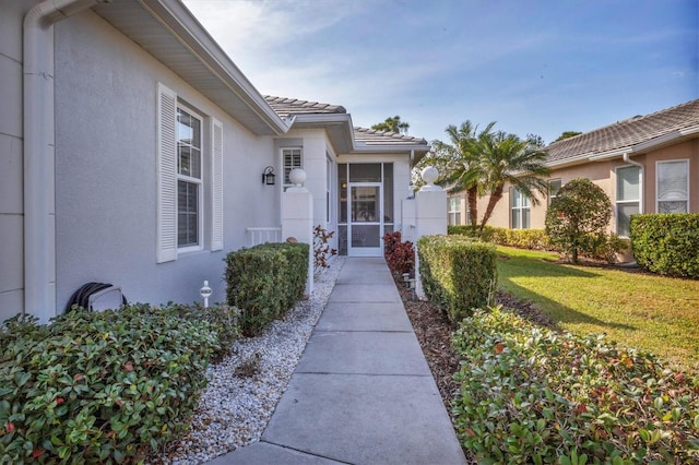 property entrance featuring a lawn