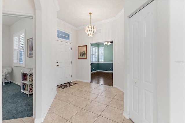 entrance foyer featuring light tile patterned floors, crown molding, and a notable chandelier