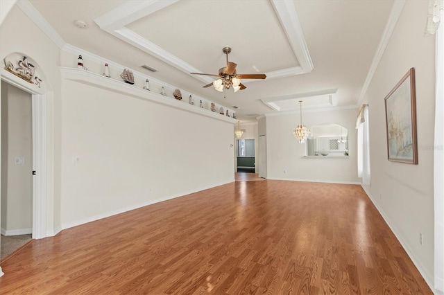 unfurnished living room with ceiling fan, wood-type flooring, a raised ceiling, and ornamental molding