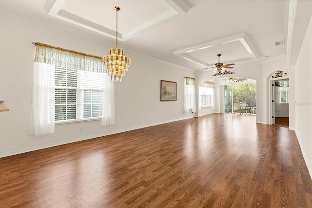 unfurnished living room featuring crown molding, a healthy amount of sunlight, ceiling fan with notable chandelier, and dark wood-type flooring