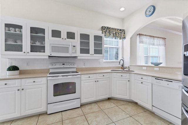 kitchen featuring white appliances, tasteful backsplash, white cabinets, sink, and light tile patterned flooring