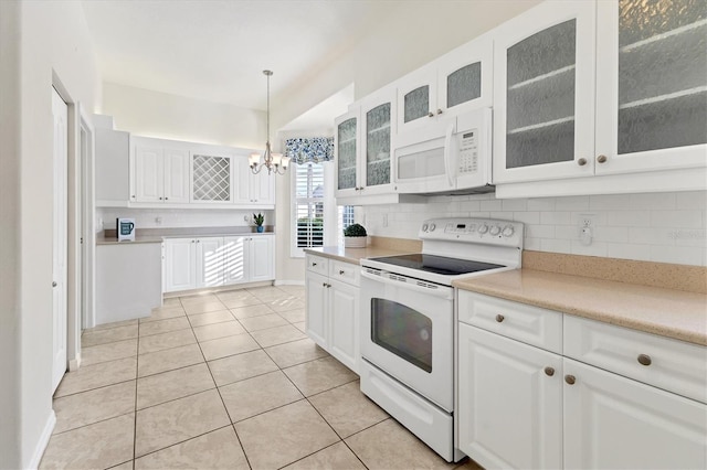 kitchen with light tile patterned floors, white appliances, white cabinets, and hanging light fixtures