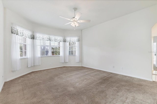 carpeted spare room featuring ceiling fan