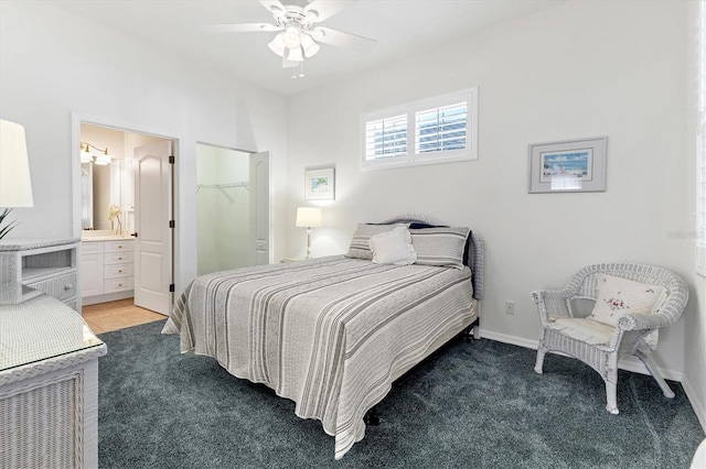 carpeted bedroom with ceiling fan, a walk in closet, a closet, and ensuite bath