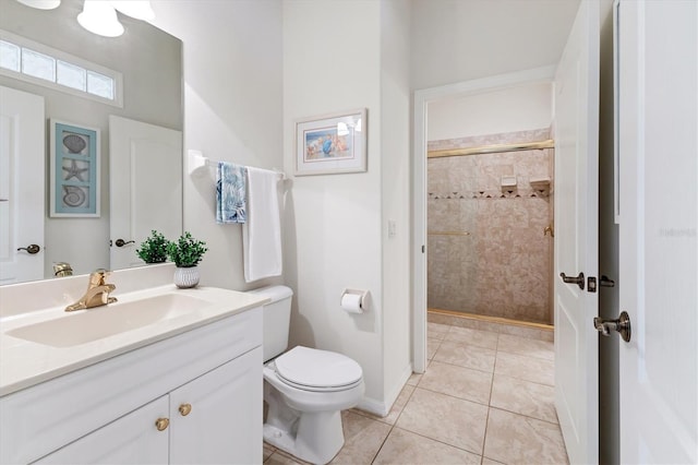 bathroom with vanity, toilet, tile patterned floors, and a tile shower