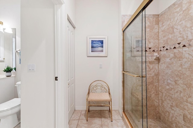 bathroom featuring a shower with shower door and toilet