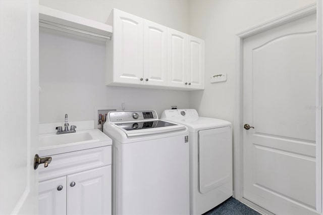 clothes washing area featuring cabinets, washer and clothes dryer, and sink