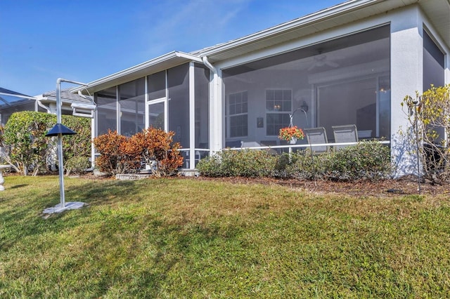 back of house with a lawn and a sunroom