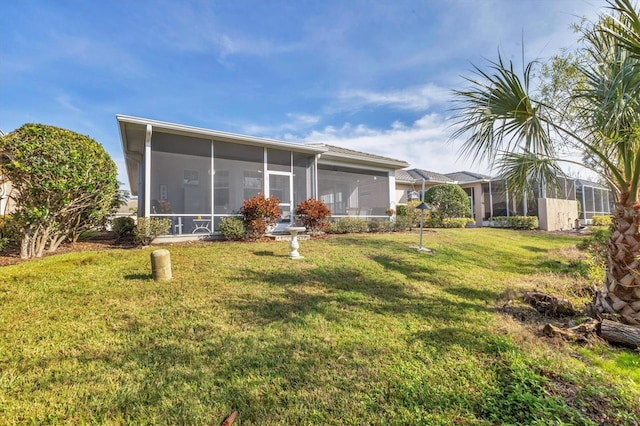 back of house featuring a sunroom and a yard