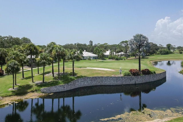 surrounding community with a water view and a lawn