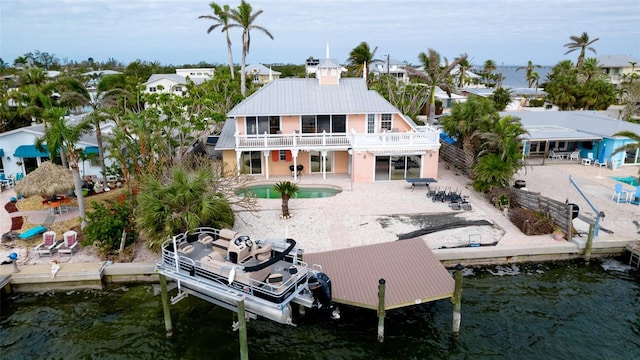 back of house featuring a water view and a patio