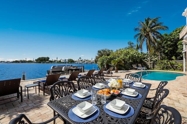 view of pool with a patio area and a water view