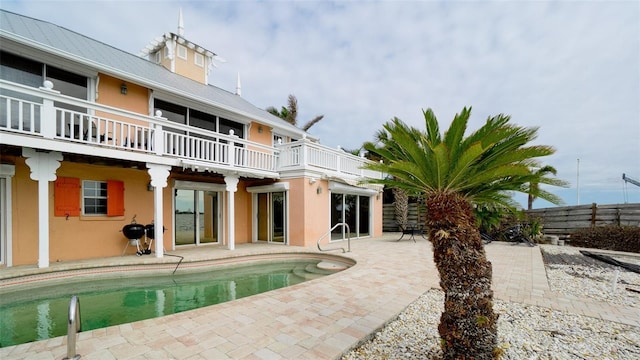 back of property featuring a balcony and a patio