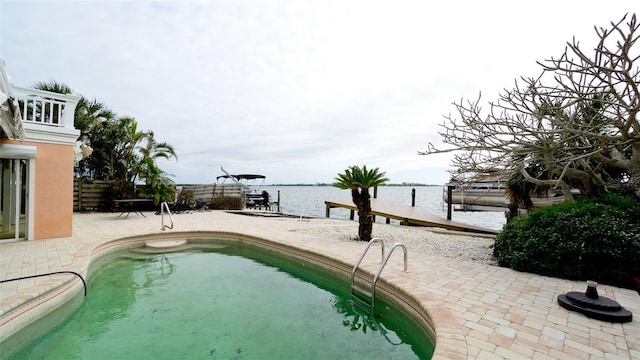 view of pool featuring a water view and a patio