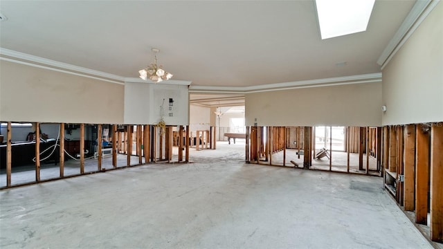 spare room featuring a skylight, a notable chandelier, ornamental molding, and concrete flooring