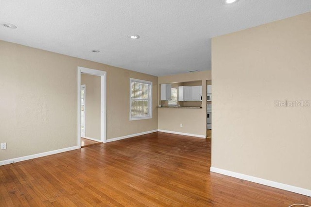 unfurnished room featuring hardwood / wood-style floors and a textured ceiling