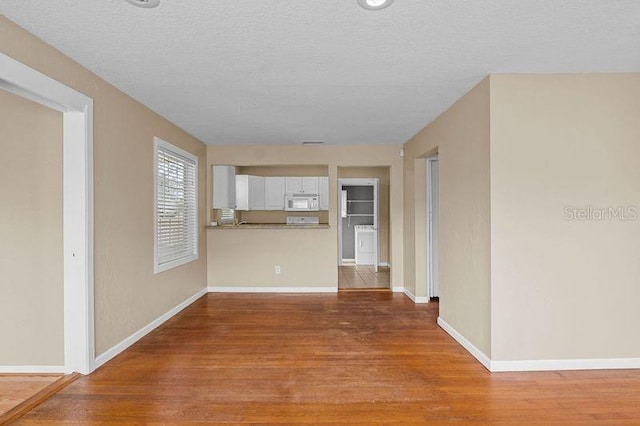 unfurnished living room with hardwood / wood-style floors and a textured ceiling