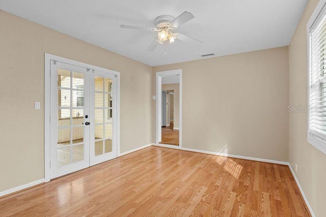 empty room with light wood-type flooring, ceiling fan, and french doors