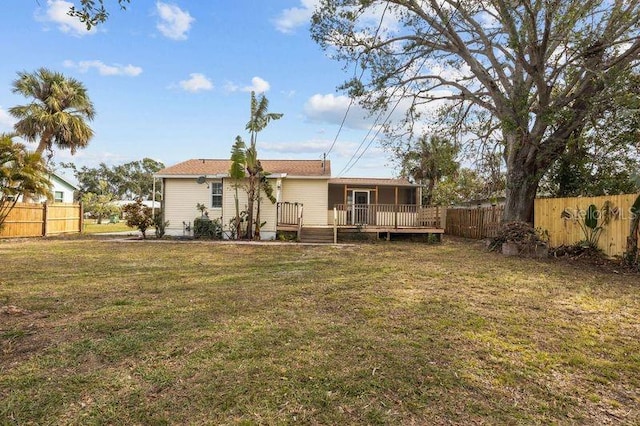 rear view of property with a deck and a lawn