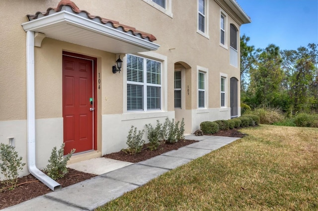 doorway to property featuring a yard