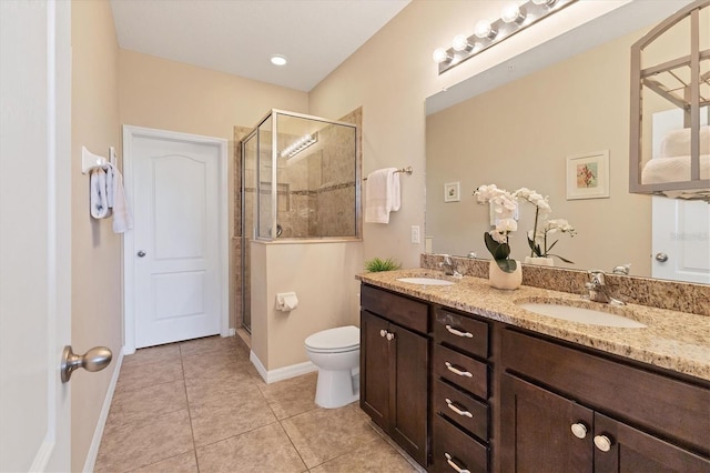 bathroom featuring tile patterned flooring, vanity, toilet, and walk in shower