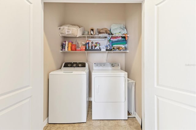 laundry area featuring light tile patterned floors and washer and clothes dryer