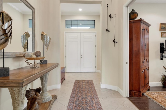 tiled foyer featuring crown molding