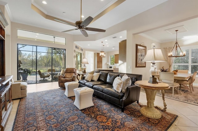 tiled living room featuring ceiling fan with notable chandelier, crown molding, and a tray ceiling