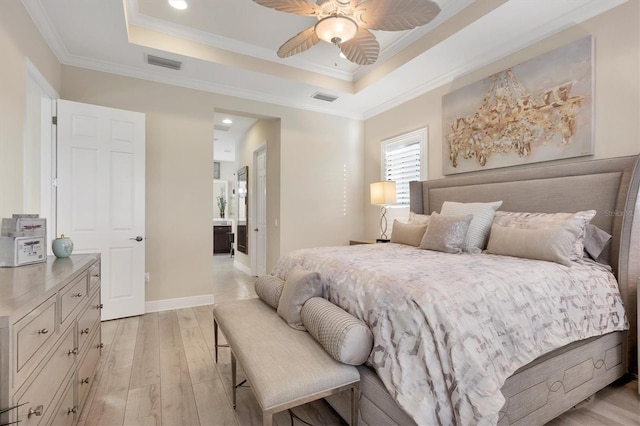 bedroom with light hardwood / wood-style floors, a tray ceiling, ceiling fan, and ornamental molding