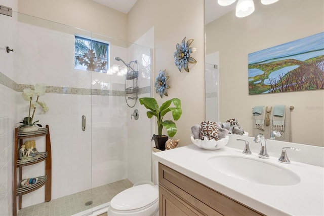 bathroom with vanity, toilet, and a shower with door