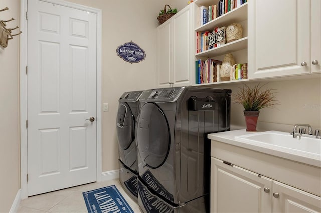 clothes washing area with cabinets, sink, light tile patterned floors, and independent washer and dryer