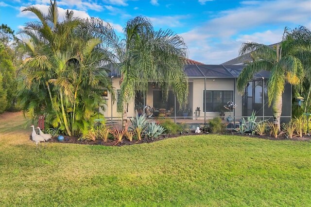 exterior space with glass enclosure and a front yard