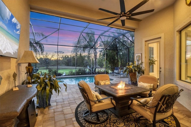 patio terrace at dusk featuring glass enclosure and an outdoor fire pit