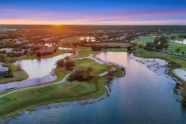 aerial view at dusk featuring a water view