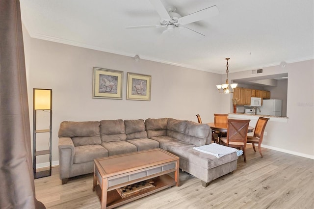 living room with crown molding, ceiling fan with notable chandelier, and light hardwood / wood-style flooring