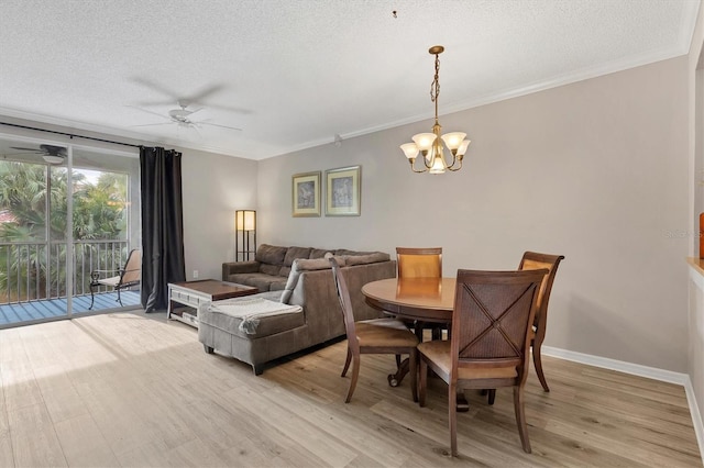 dining area with light wood-type flooring, ornamental molding, a textured ceiling, and ceiling fan with notable chandelier