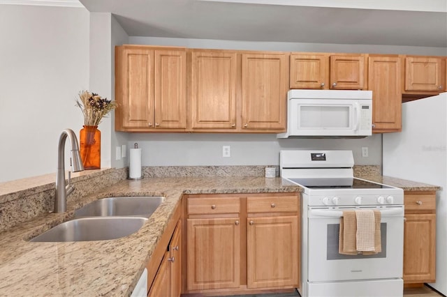 kitchen featuring light stone countertops, sink, and white appliances