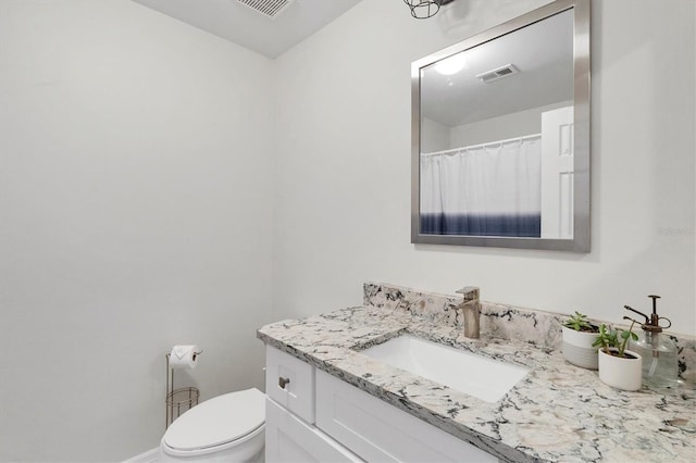 bathroom featuring toilet and vanity