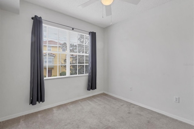 unfurnished room with ceiling fan, light colored carpet, and a wealth of natural light