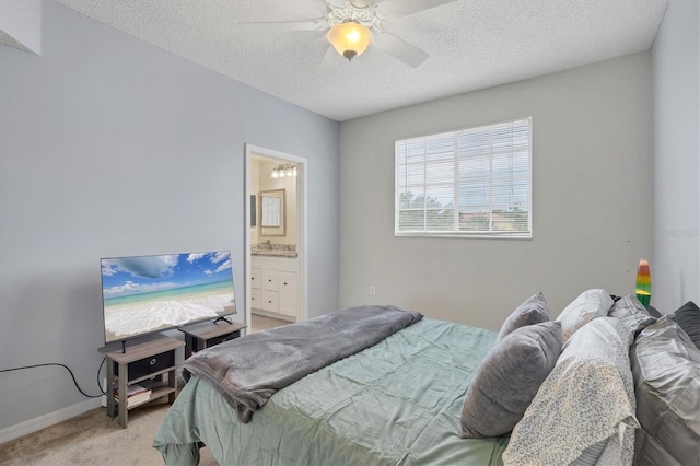 carpeted bedroom with a textured ceiling, ceiling fan, and ensuite bathroom