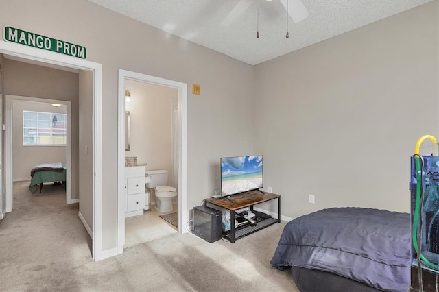 carpeted bedroom featuring ceiling fan, connected bathroom, and a textured ceiling