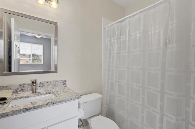 bathroom with toilet, vanity, and curtained shower