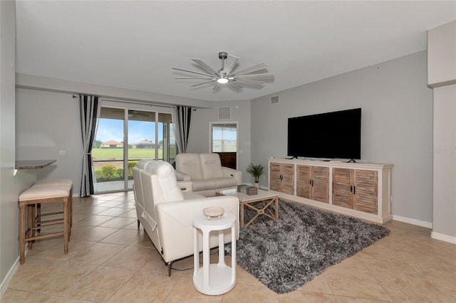 living area with light tile patterned floors, visible vents, baseboards, and ceiling fan