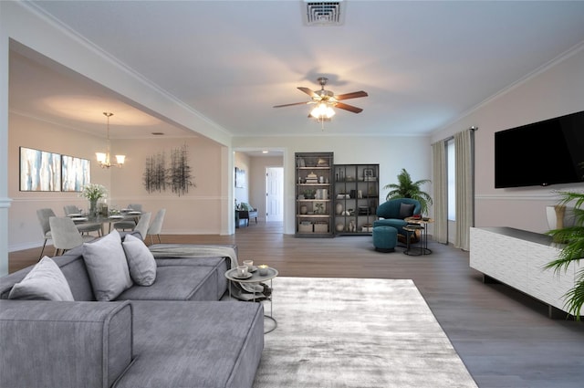 living room featuring ceiling fan with notable chandelier, crown molding, and hardwood / wood-style flooring