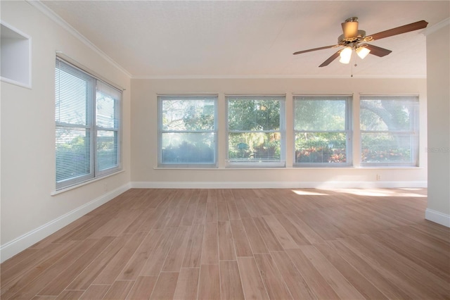 interior space with light wood-type flooring, ceiling fan, a wealth of natural light, and ornamental molding