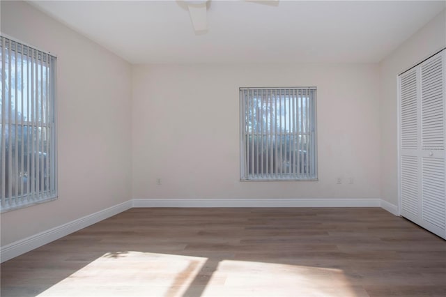 unfurnished bedroom featuring ceiling fan, a closet, and hardwood / wood-style floors