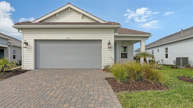 view of front of home featuring a garage and central AC unit