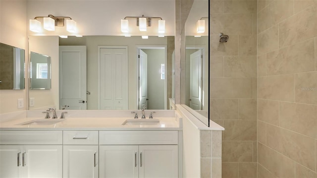 bathroom with tiled shower and vanity