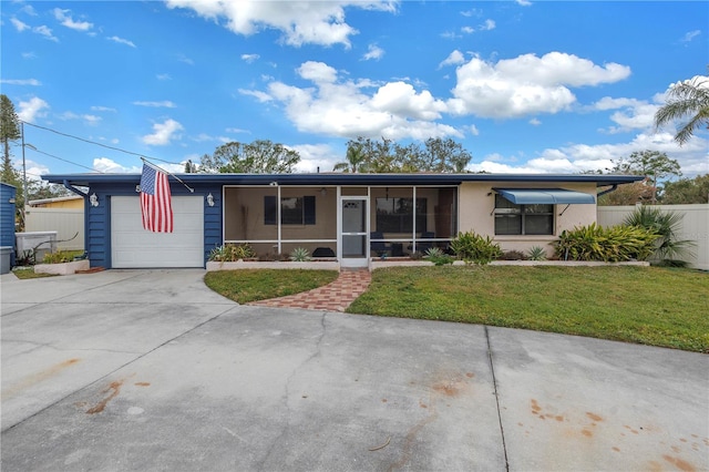 view of front of home with a front yard, a garage, and a sunroom